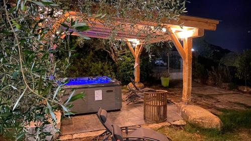 a backyard with a gazebo and a hot tub at night at Résidence A CASA VECCHIA gites de charme avec JACUZZI proche Ajaccio in Peri