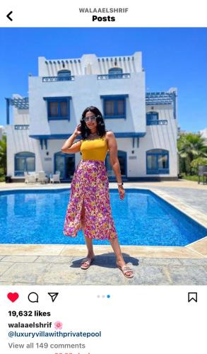 a woman talking on a cell phone in front of a pool at Luxury Villa with pool in Hurghada in Hurghada