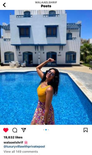 a woman standing in front of a swimming pool at Luxury Villa with pool in Hurghada in Hurghada
