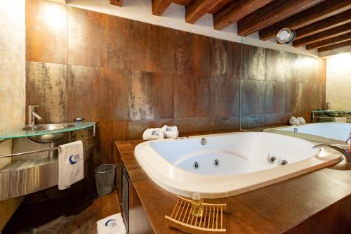 a bathroom with a large tub and a sink at Hotel Boutique Casona de la China Poblana - Adults Only in Puebla