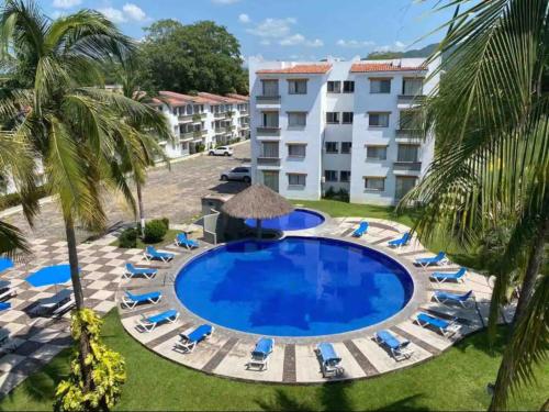 une image de la piscine d'un complexe dans l'établissement Hermoso condominio con alberca y club de playa!!, à Manzanillo