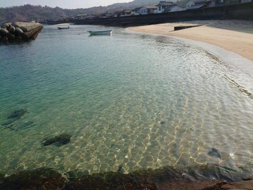 a beach with a boat in the water at 風早邸海音 kazahayatei mion in Hōjō