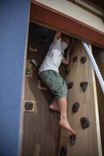 a young boy is climbing up a wooden troop at 風早邸海音 kazahayatei mion in Hōjō