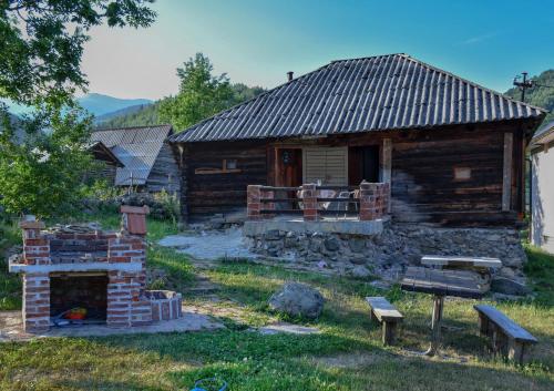 a log cabin with a fireplace in front of it at Lubnice - Seoska kuca in Berane