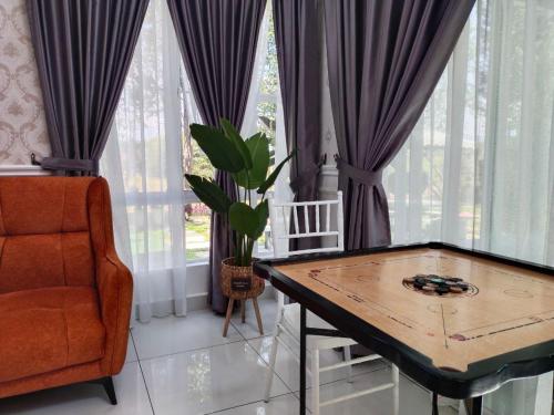 una sala de estar con una mesa y una silla en Laman Jubilee DBayu, en Mantin