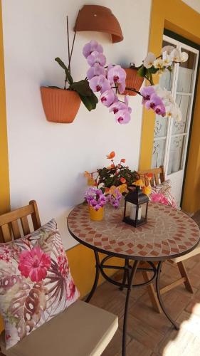 a room with a table with flowers on it at Paradise-AL in Porto Covo