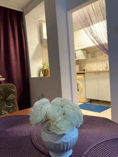 a vase filled with white flowers sitting on a table at Royal Studio National Arena - Free Parking in Bucharest