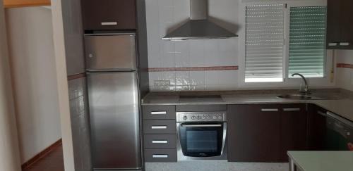 a kitchen with a stainless steel refrigerator and a sink at Pozo de esparto in El Pozo del Esparto