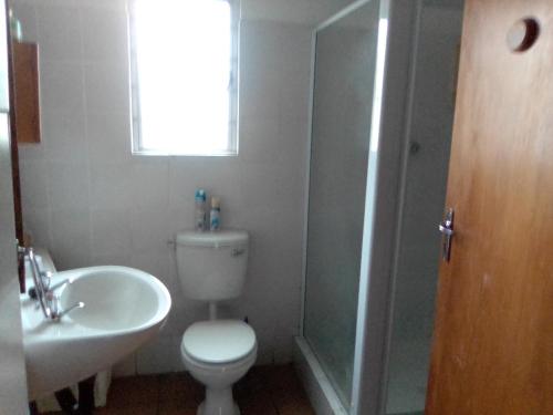 a bathroom with a toilet and a sink and a shower at Peacefull Memories in Cintsa Mouth West