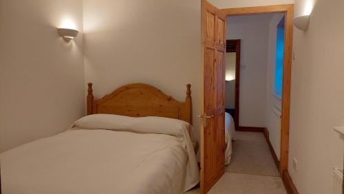 a bedroom with a bed and an open door at Holiday Cottage in Devon near Beaches and National Parks in Honiton