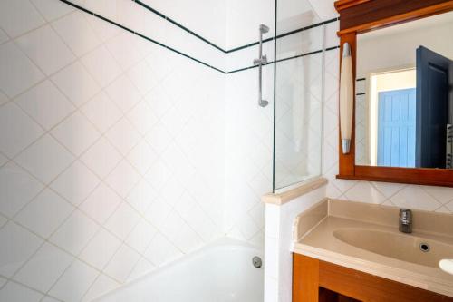 une salle de bain avec un lavabo, un miroir et une baignoire dans l'établissement Appartement sur golf avec piscine chauffée à Lacanau-Océan, à Lacanau