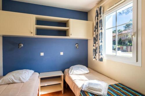 deux lits jumeaux dans une chambre avec fenêtre dans l'établissement Appartement sur golf avec piscine chauffée à Lacanau-Océan, à Lacanau