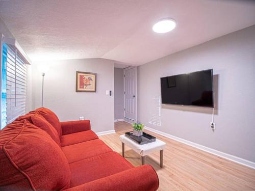 a living room with a red couch and a tv at Homey Bungalow Convenient to Marietta and I-75! in Marietta