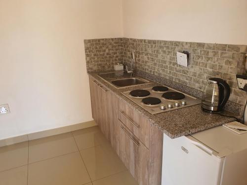 a kitchen with a sink and a stove top oven at BF Dlamini Guesthouse in Amanzimtoti