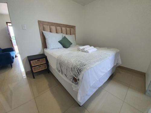 a bedroom with a large bed with white sheets at BF Dlamini Guesthouse in Amanzimtoti