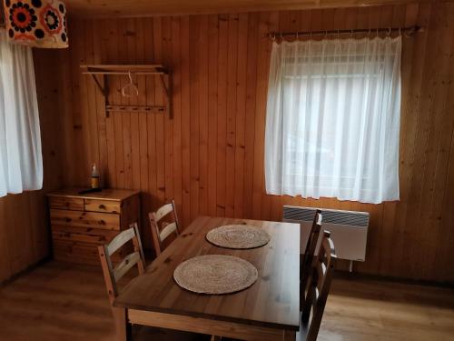 a dining room with a wooden table and chairs at Ala i Tomek domki in Łeba