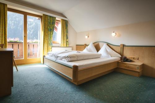 a bedroom with a bed and a large window at Hotel Die Arlbergerin - Design & Tiroler Gemütlichkeit in Sankt Anton am Arlberg