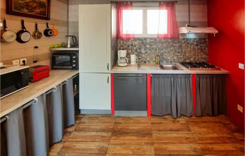 - une cuisine avec des placards rouges et blancs et un évier dans l'établissement 2 Bedroom Beautiful Home In Plogoff, à Plogoff