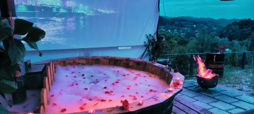 a hot tub filled with red peppers in front of a window at Stablo guest house in Bărăşti