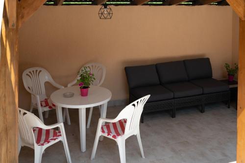 a patio with a table and chairs and a couch at Приватна садиба Затишок in Kosonʼ