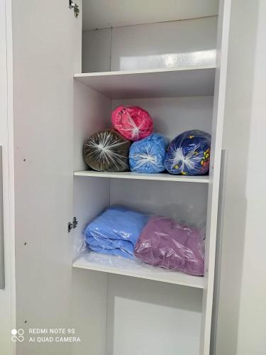 a shelf with several different colored bags on it at Casa Agradável próxima ao Bosque in Pôrto Feliz