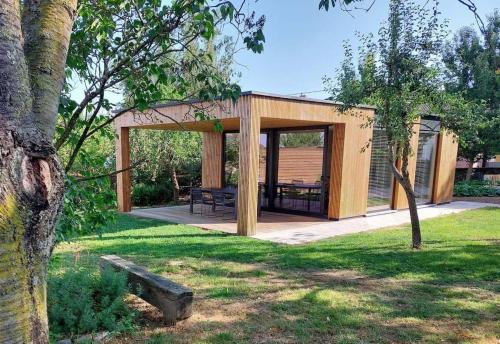 einem Holzpavillon mit einem Picknicktisch in einem Park in der Unterkunft Geniet van alle comfort tussen Ieper en Heuvelland in Ypern