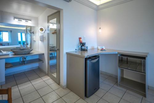 ein Badezimmer mit einem Waschbecken und einer Theke mit einem Waschbecken in der Unterkunft Hotel Oasis in Loreto