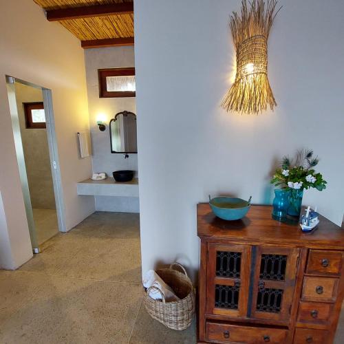 a bathroom with a wooden dresser and a mirror at Coco Pontall Bangalôs in Coruripe