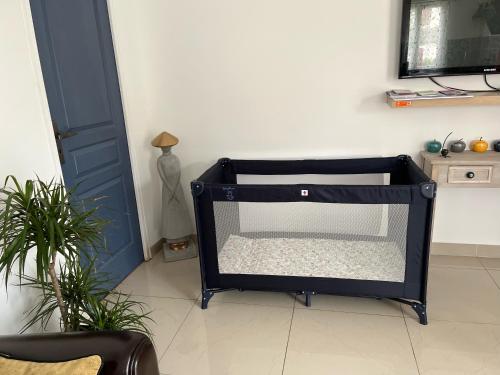 a black dog crate sitting in a room with a door at maison entre Disneyland et Paris in Meaux