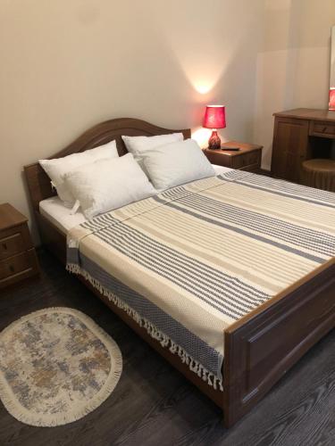 1 dormitorio con 1 cama grande con lámpara y alfombra en Old batumi apartment on kostava 9 en Batumi