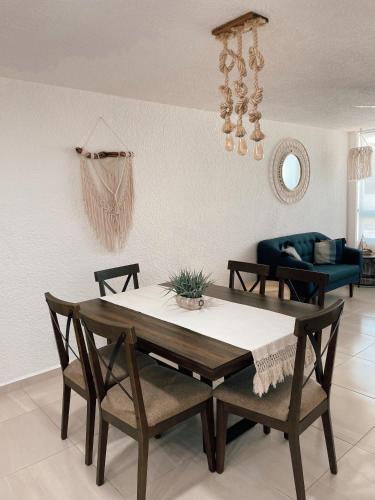 a dining table and chairs in a living room at Hermoso Departamento Nuevo a 50 metros de playa!! in Manzanillo