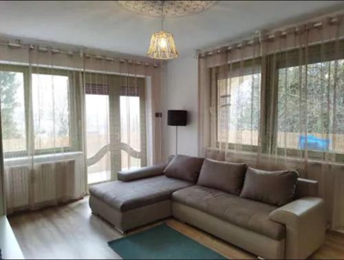 sala de estar con sofá y algunas ventanas en Csendes Vendégház, Families, Hikers & Bikers, en Cserszegtomaj