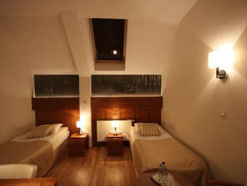 a hotel room with two beds and two tables at Hotel Vabank in Golub-Dobrzyń