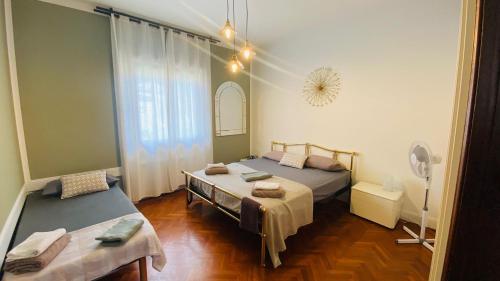 1 dormitorio con 2 camas y ventana en Villa Flora Affittacamere, en Luni