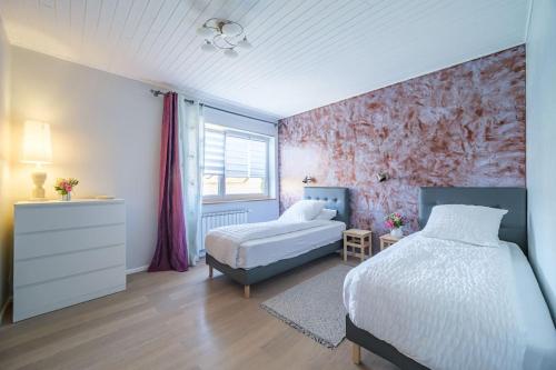 1 dormitorio con 2 camas y ventana en Cosy Home in South Alsace for work and leisure, en Pfastatt