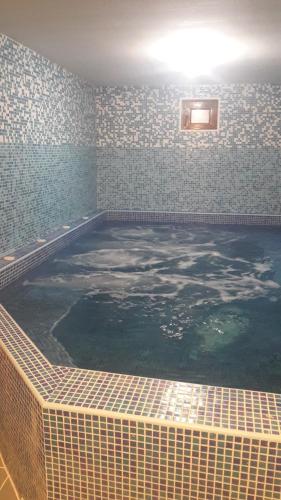 a large swimming pool in a room with a tile wall at Guest House Todorini kashti in Koprivshtitsa