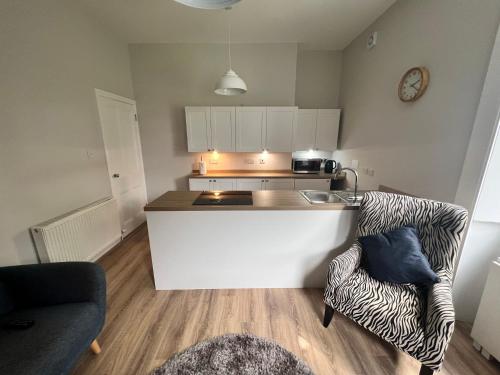 a kitchen with a counter and a couch in a room at Central Helensburgh 1 BR, gr floor pet friendly in Helensburgh