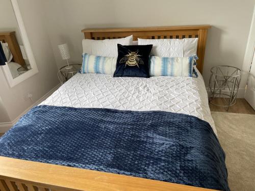 uma cama com um edredão e almofadas azuis e brancas em Central Helensburgh 1 BR, gr floor pet friendly em Helensburgh