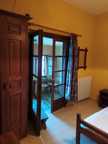 a room with a door leading to a dining room at Double studio room in front of the sea in Tsagarada