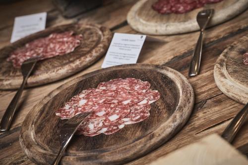 a table topped with plates of meat and utensils at Tenne Lodges in Racines
