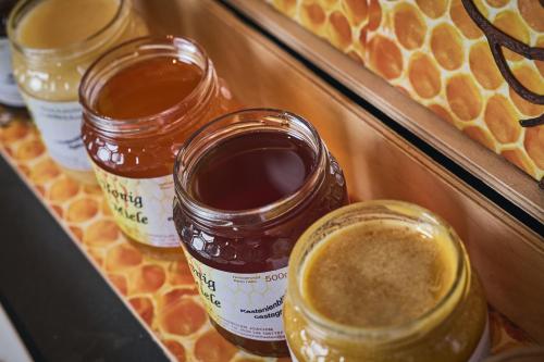 three jars of honey sitting on a shelf at Tenne Lodges in Racines