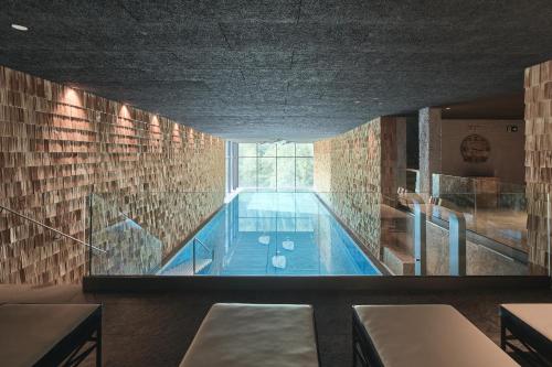 a swimming pool in a building with a large window at Tenne Lodges in Racines