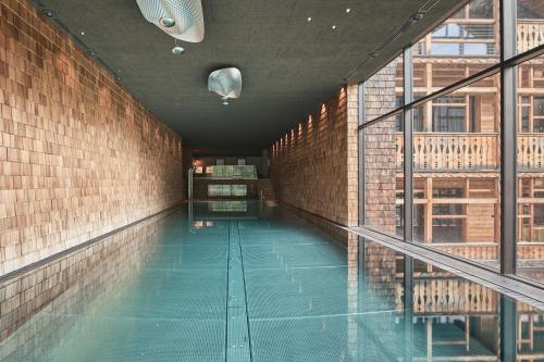 a swimming pool in a building with a brick wall at Tenne Lodges in Racines