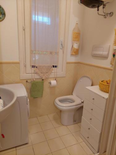 bagno bianco con servizi igienici e lavandino di Appartamento a Punta Asfodeli a Porto Rotondo