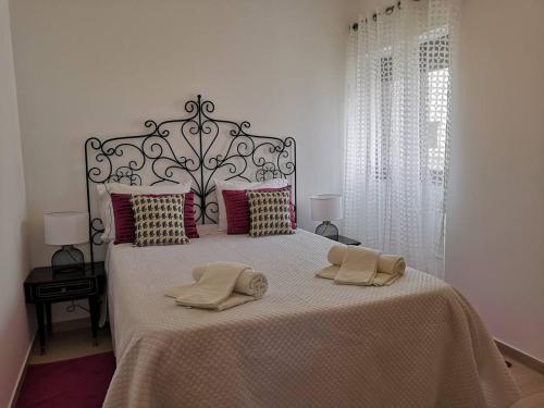 ein Schlafzimmer mit einem großen Bett mit zwei Handtüchern darauf in der Unterkunft Casa da Zira II - Vista de Mar in Nazaré