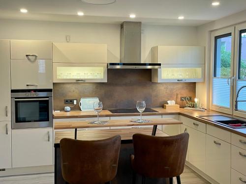 a kitchen with two wine glasses on a table at Wellnesshome Fontaneweg mit Sauna, Terrasse und Garten in Espelkamp