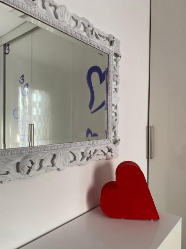 a red heart sitting on a counter next to a mirror at Petit place incantevole a due passi da Milano! in Cologno Monzese