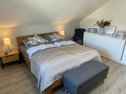 1 dormitorio con 1 cama grande con reposapiés azul en Neu! Wellnesshome Fontaneweg Sauna, Terasse, Garten Erstbezug Juli 2022, en Espelkamp