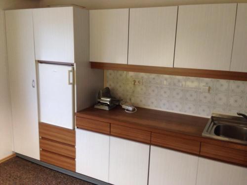 eine Küche mit weißen Schränken und einem Waschbecken in der Unterkunft Ferienwohnung Lechner in Karres