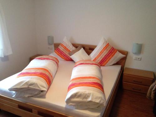 a bed with four pillows on top of it at Ferienwohnung Lechner in Karres
